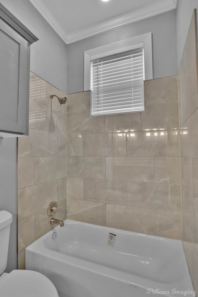 bathroom featuring tiled shower / bath combo and toilet