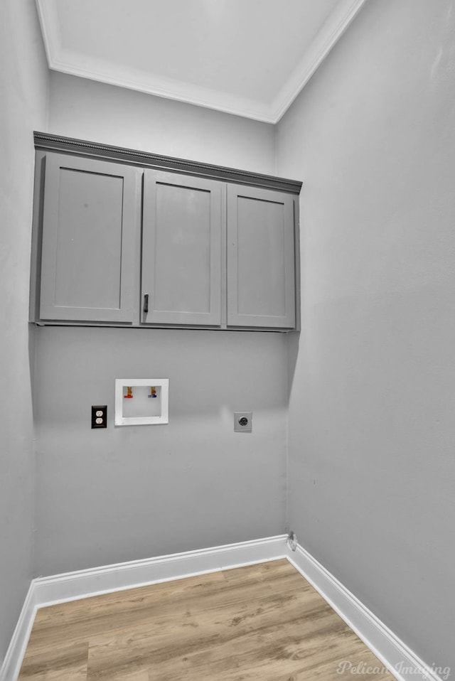 washroom featuring electric dryer hookup, hookup for a washing machine, light hardwood / wood-style floors, and ornamental molding