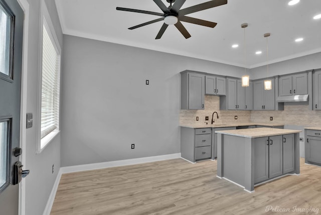 kitchen featuring decorative backsplash, gray cabinetry, ceiling fan, crown molding, and pendant lighting