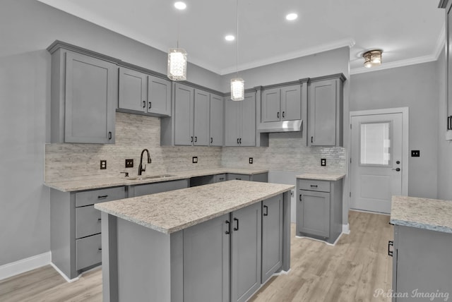 kitchen with ornamental molding, sink, a center island, gray cabinets, and hanging light fixtures