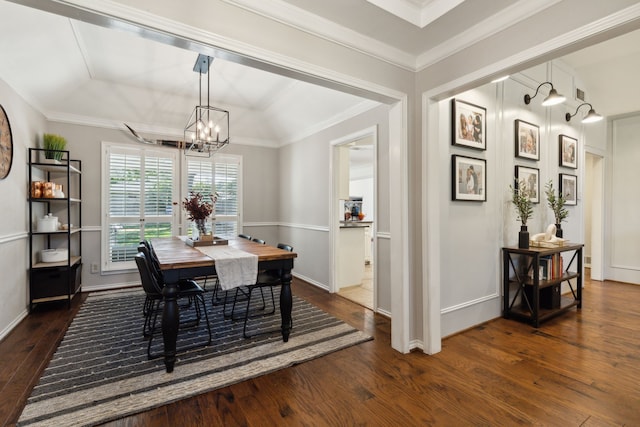 dining area with a notable chandelier, ornamental molding, and dark wood-type flooring