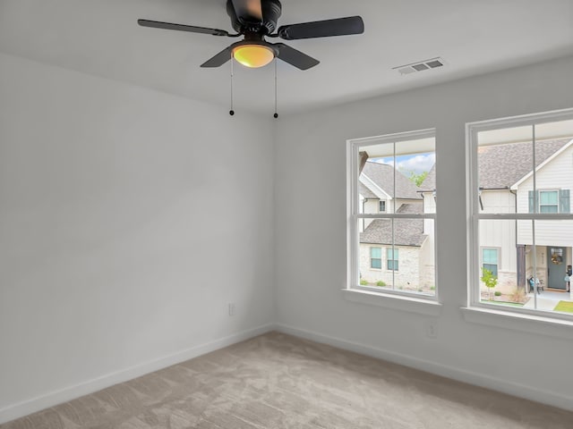 carpeted spare room featuring ceiling fan