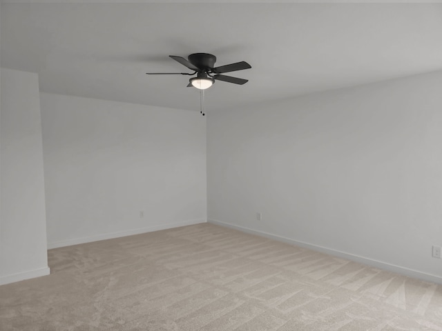 spare room featuring light colored carpet and ceiling fan