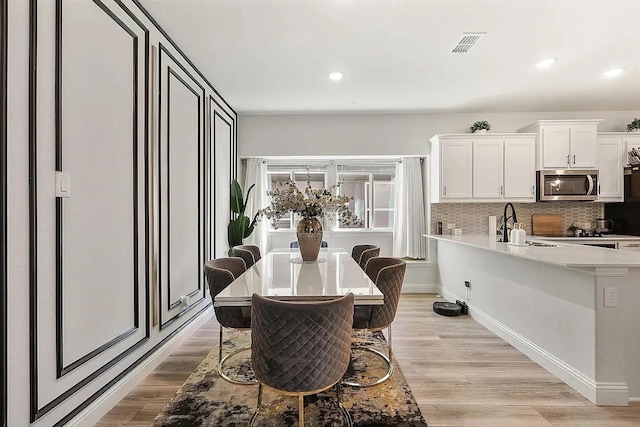 dining area featuring light hardwood / wood-style flooring and sink