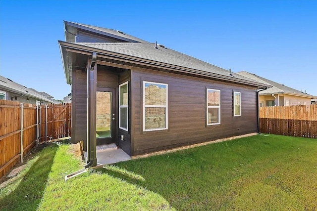 rear view of house featuring a lawn