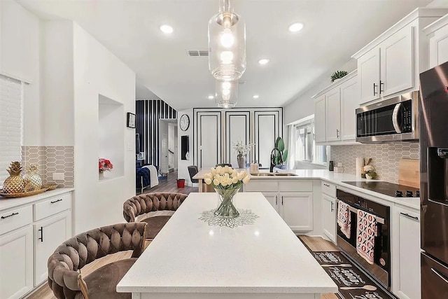 kitchen with white cabinets, decorative backsplash, sink, and appliances with stainless steel finishes