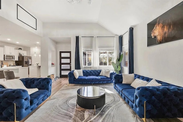 living room with light hardwood / wood-style floors and vaulted ceiling