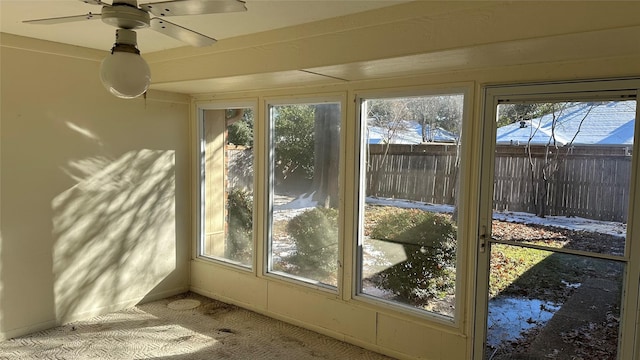 unfurnished sunroom featuring ceiling fan