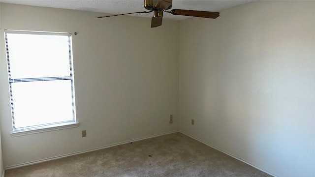 carpeted spare room featuring ceiling fan