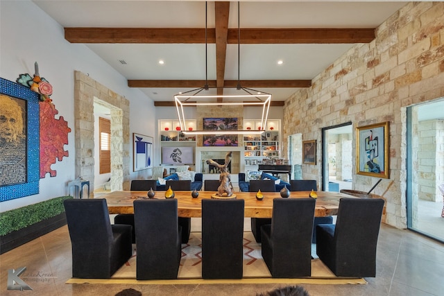 dining area with beamed ceiling, a wealth of natural light, and built in shelves