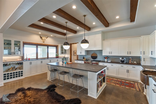 kitchen with white cabinetry, decorative light fixtures, a center island, and a breakfast bar