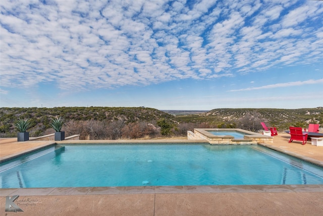 view of swimming pool featuring an in ground hot tub