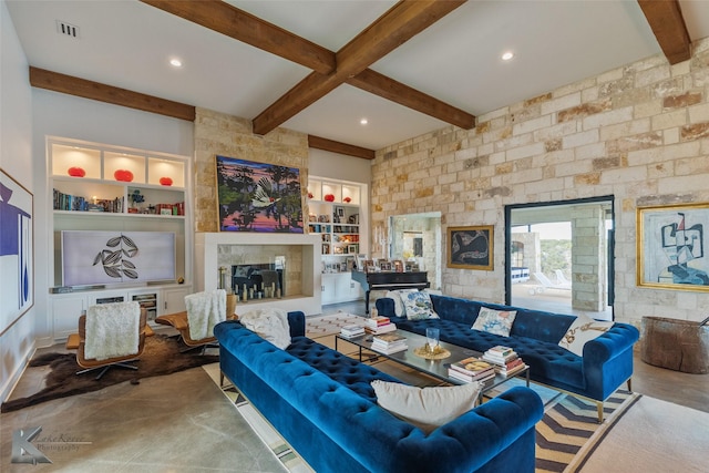 living room with beamed ceiling, a large fireplace, and built in features