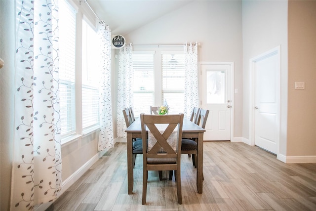 dining room featuring lofted ceiling and light wood-type flooring