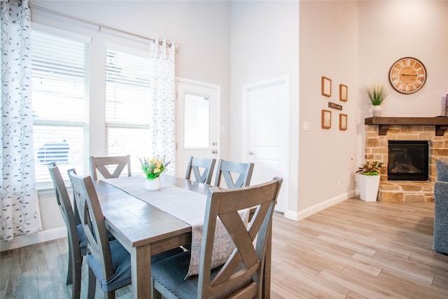 dining area featuring a fireplace and light wood-type flooring