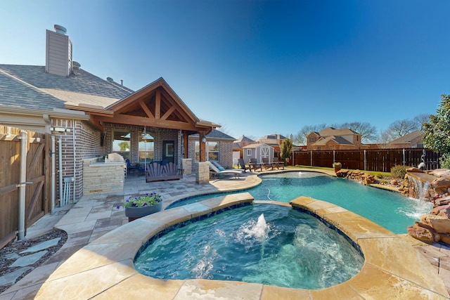 view of pool with pool water feature, a patio area, and an in ground hot tub