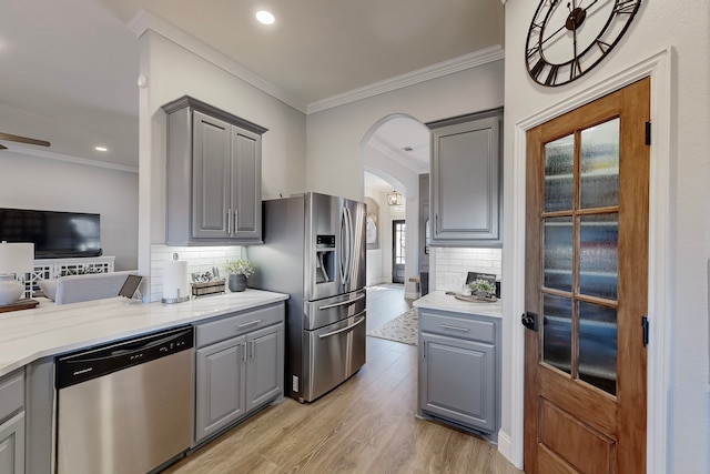 kitchen with gray cabinets, backsplash, and appliances with stainless steel finishes