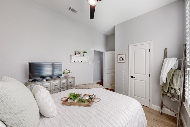 bedroom with light hardwood / wood-style flooring, vaulted ceiling, and ceiling fan