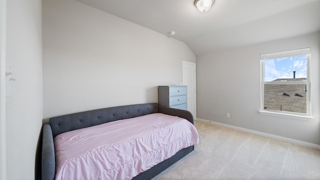 bedroom with light carpet and lofted ceiling