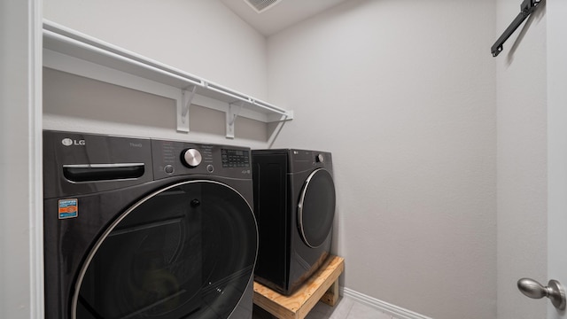 laundry area featuring independent washer and dryer and light tile patterned flooring