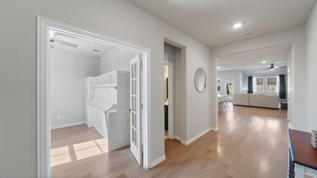 corridor featuring light hardwood / wood-style flooring and french doors