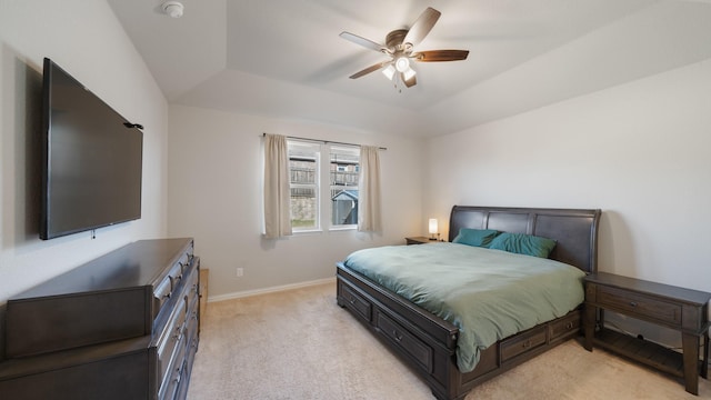 carpeted bedroom with a tray ceiling, ceiling fan, and lofted ceiling