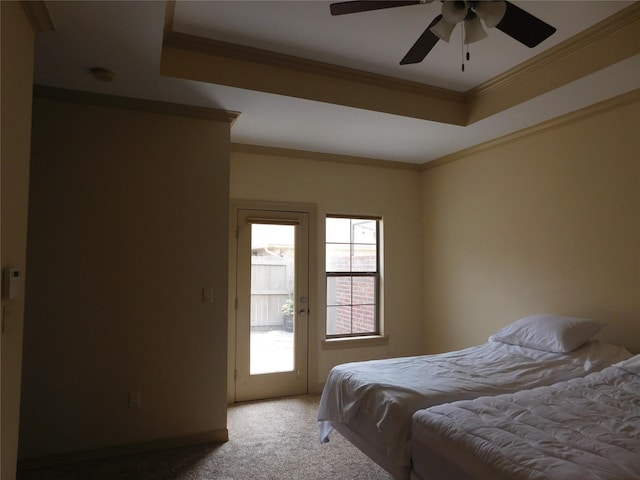 carpeted bedroom featuring ceiling fan, a raised ceiling, and crown molding