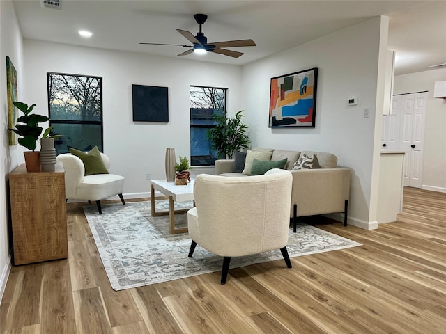 living room featuring ceiling fan and light hardwood / wood-style flooring