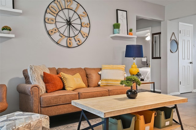 living room featuring wood-type flooring and ceiling fan