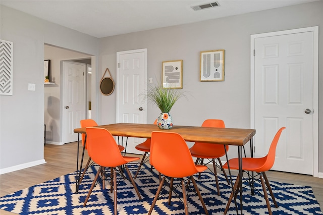 dining space with wood-type flooring