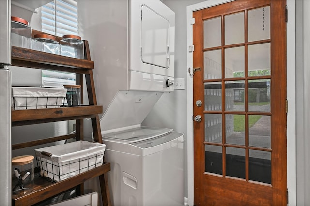 clothes washing area featuring a wealth of natural light and stacked washer and clothes dryer