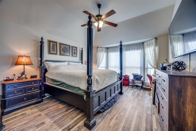 bedroom with ceiling fan, lofted ceiling, and light wood-type flooring