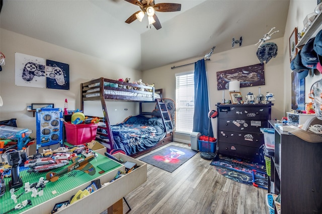 bedroom with hardwood / wood-style flooring, ceiling fan, and vaulted ceiling