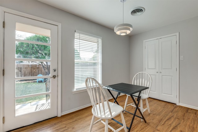 dining room with plenty of natural light and light hardwood / wood-style flooring