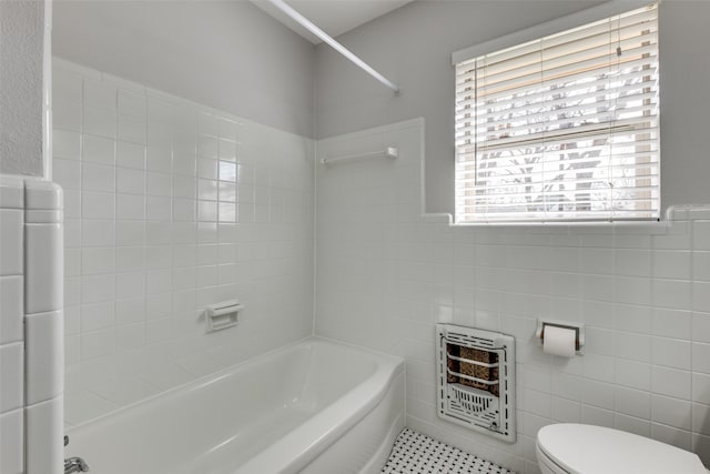 bathroom featuring heating unit, a wealth of natural light, tile walls, and toilet