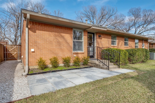 ranch-style house with a front lawn, a patio, and central AC