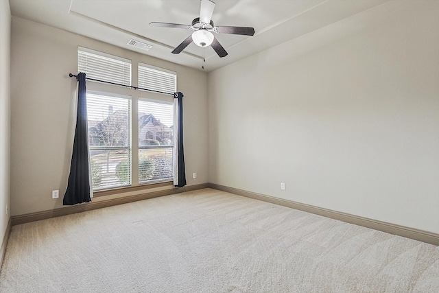 spare room with ceiling fan and light colored carpet