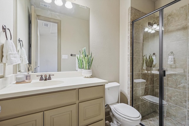 bathroom featuring an enclosed shower, vanity, and toilet