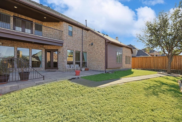 rear view of property featuring a yard and a patio