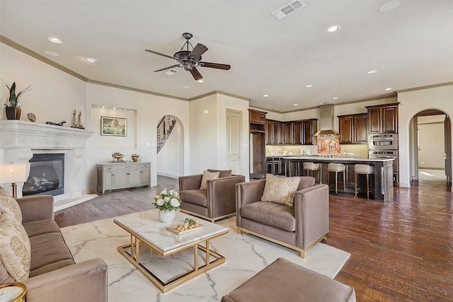 living room with sink, ceiling fan, hardwood / wood-style flooring, and ornamental molding