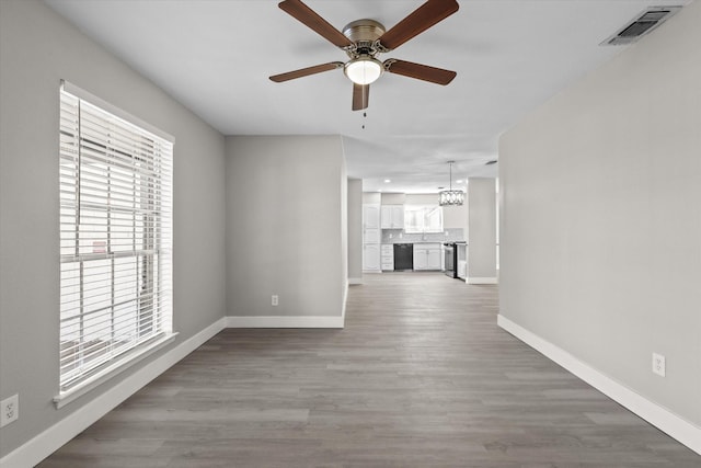 interior space featuring ceiling fan with notable chandelier and wood-type flooring