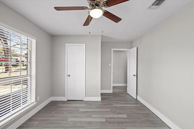 unfurnished bedroom with a closet, light hardwood / wood-style floors, and ceiling fan