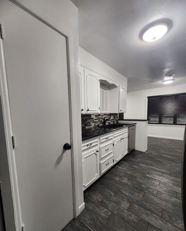 kitchen featuring tasteful backsplash, white cabinetry, appliances with stainless steel finishes, and dark hardwood / wood-style floors