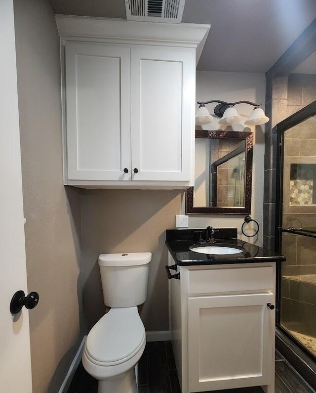 bathroom featuring a shower with door and vanity