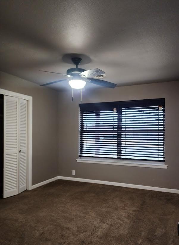 unfurnished bedroom featuring carpet floors, ceiling fan, and a closet