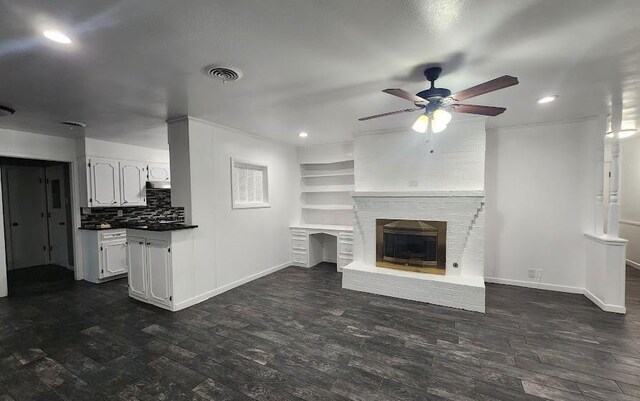 unfurnished living room featuring ceiling fan, dark hardwood / wood-style floors, and a fireplace