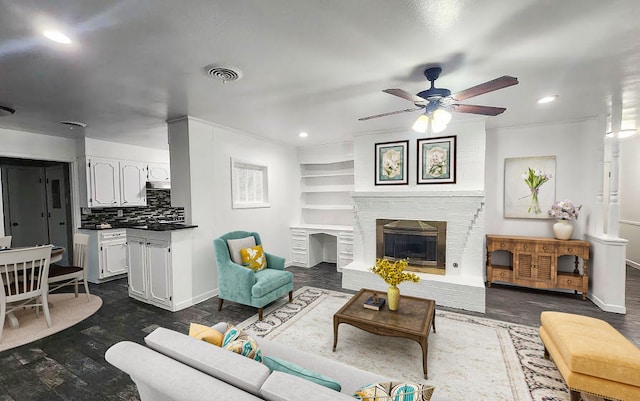 1911 College St, Gainesville, TX 76240 - living area featuring ceiling fan, baseboards, dark wood-type flooring, recessed lighting, and a brick fireplace