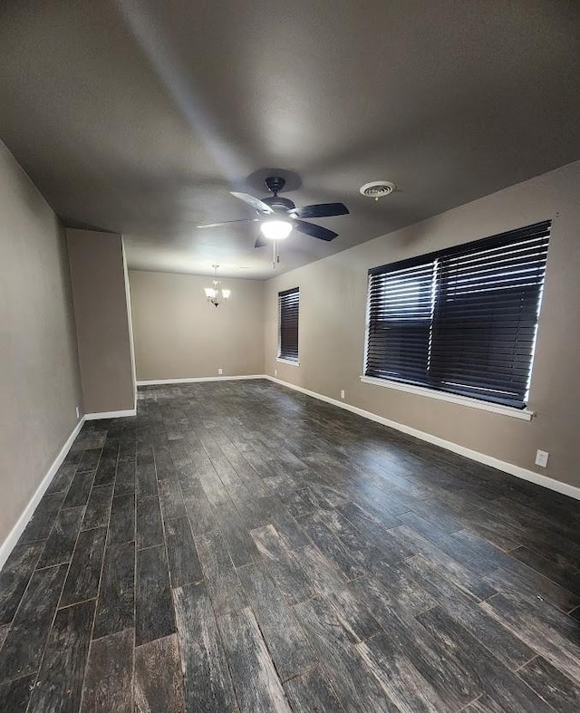 unfurnished living room featuring dark wood-type flooring and ceiling fan