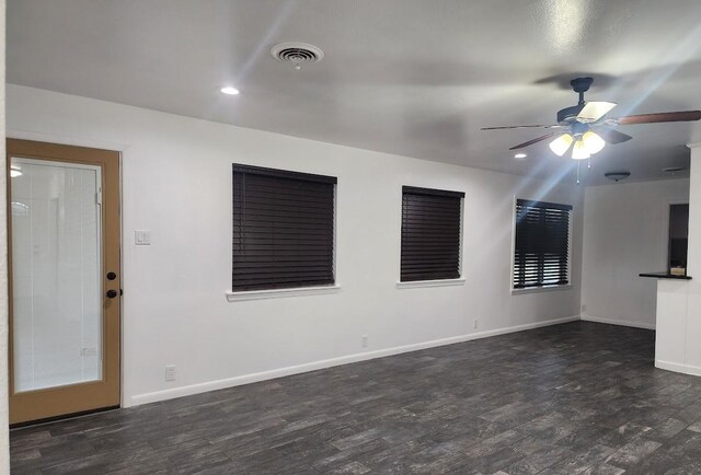 unfurnished living room featuring ceiling fan, dark wood-type flooring, a textured ceiling, and a fireplace