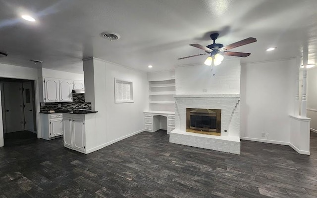 1911 College St, Gainesville, TX 76240 - unfurnished living room with ceiling fan, dark wood finished floors, baseboards, recessed lighting, and a brick fireplace